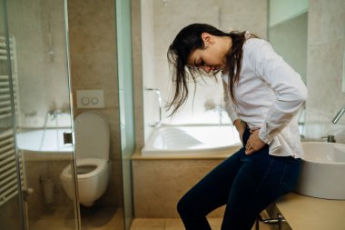 Şiddetli karın ağrısı çeken bir kadın. Gastrointestinal otoimmün hastalık. Dysmenorrhea / endometriyozis. Gastrointestinal sorun.