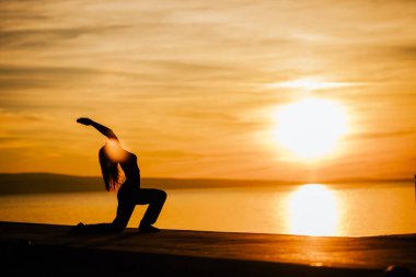 Düşüncesiz bir kadın doğası gereği meditasyon yapıyor. İç huzuru buluyor. Yoga yapıyor. İyileştirici bir yaşam tarzı. Huzurun, stres terapisinin, farkındalık meditasyonunun tadını çıkarıyor.