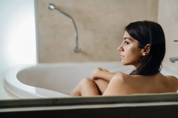 Calm woman having a relaxing bath at home.Spa self care night.Bathroom personal hygiene routine.Relaxing home activity.Body nourishment.Stress relief after work