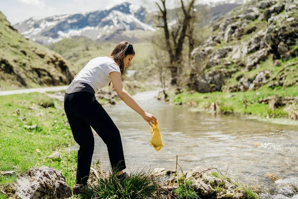Γυναίκα Εθελοντής Περπατώντας Κατά Μήκος Όχθης Του Ποταμού Μαζεύοντας Σκουπίδια — Φωτογραφία Αρχείου