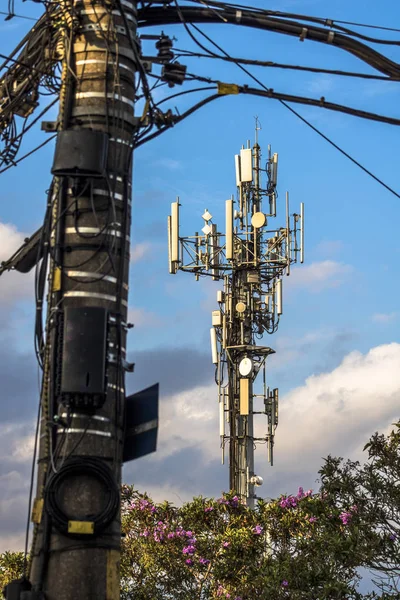 Telecommunication tower with copy space.Digital wireless connection system.Development of communication systems in urban areas.Modern Business Communication Concept.Antenna, and pole with electric line in Sao Paulo
