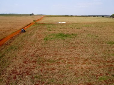 Brezilya 'da soya yetiştirmek için toprağı harap eden bir traktörün hava görüntüsü.
