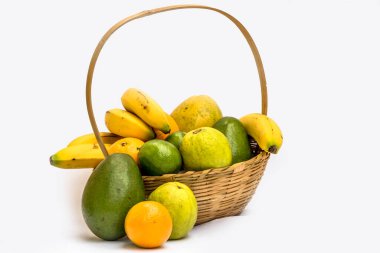 Avokado, papaya, portakal, muz, guava ve limon bambudan bir sepetin içinde, beyaz arka planda.