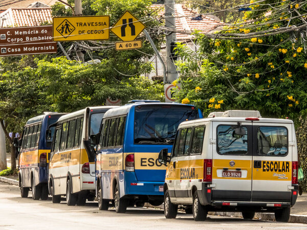 Sao Paulo, Brazil, March 29, 2019. Vans and school buses parked on a street in the Vila Mariana neighborhood, south of Sao Paulo