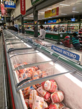 Marilia, Sao Paulo, Brezilya, 24 Ağustos 2019. İnsanlar dondurulmuş gıda dolabındaki ürünleri süpermarketten seçiyor.