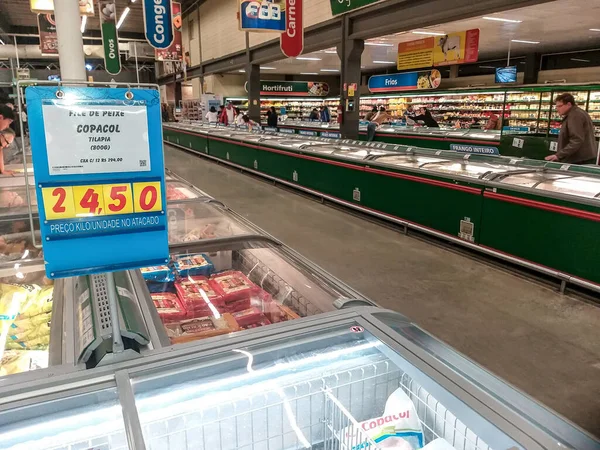 Marilia, Sao Paulo, Brezilya, 24 Ağustos 2019. İnsanlar dondurulmuş gıda dolabındaki ürünleri süpermarketten seçiyor.