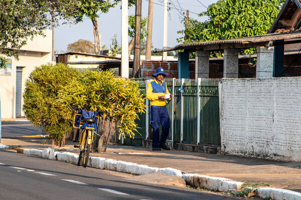 Quintana, Sao Paulo, Brazil, September 13, 2019. The postman on a bicycle on a street of Quintana, central-western region of the State of Sao Paulo