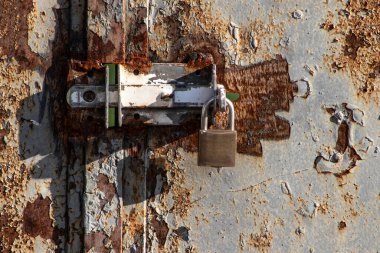 Padlock closing a rusty iron gate