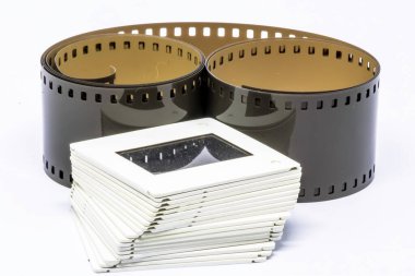 Yuvarlanmamış film şeridi ve film slaytı beyaz arkaplanda izole edilmiş 35 mm yığın
