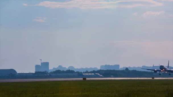 เครื่องบินบนพื้นหลังของภูมิทัศน์เมืองในเมืองของสนามบิน Omsk ในไซบีเรียในฤดูร้อน — วีดีโอสต็อก