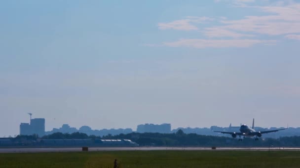 เครื่องบินบนพื้นหลังของภูมิทัศน์เมืองในเมืองของสนามบิน Omsk ในไซบีเรียในฤดูร้อน — วีดีโอสต็อก