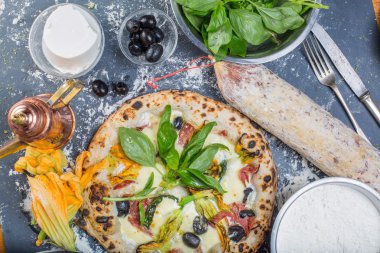 Kara tahta üzerinde mozzarella, salam, ricotta ve kabak çiçekleri ile geleneksel İtalyan pizza