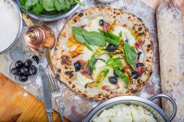 Kara tahta üzerinde mozzarella, salam, ricotta ve kabak çiçekleri ile geleneksel İtalyan pizza