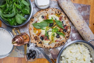 Kara tahta üzerinde mozzarella, salam, ricotta ve kabak çiçekleri ile geleneksel İtalyan pizza