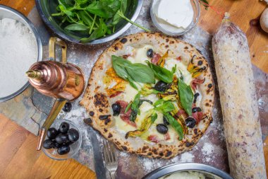 Kara tahta üzerinde mozzarella, salam, ricotta ve kabak çiçekleri ile geleneksel İtalyan pizza