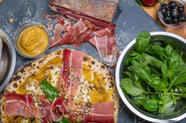Kabak pesto, jambon, gorgonzola ve tohumlar Siyah Kara tahta üzerinde geleneksel İtalyan pizza