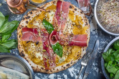 Kabak pesto, jambon, gorgonzola ve tohumlar Siyah Kara tahta üzerinde geleneksel İtalyan pizza