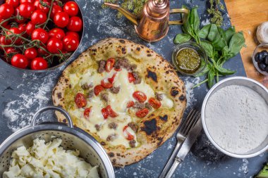 Geleneksel İtalyan pizza domates, salsicia ve pesto ile 