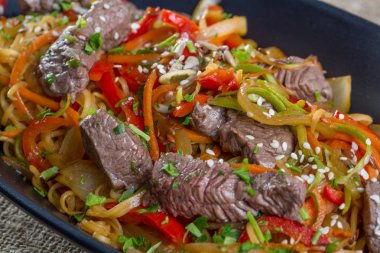 Sığır kesim, sebze ve siyah bir tabak spagetti yakın çekim