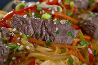 Sığır kesim, sebze ve siyah bir tabak spagetti yakın çekim