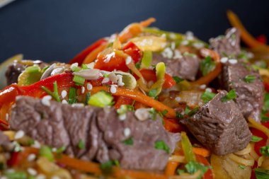 Sığır kesim, sebze ve siyah bir tabak spagetti yakın çekim