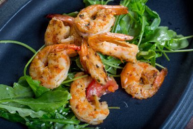 siyah bir plaka üzerinde roka ile taze kızarmış shirmps ile yakın