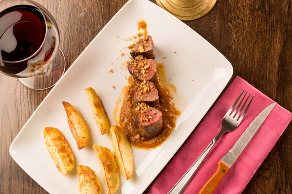 Domuz biftek patates ve bir kadeh şarap ile yakın çekim — Stok fotoğraf