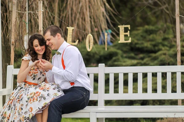 Ung härlig par leker och skrattar nära ett tecken på kärlek — Stockfoto