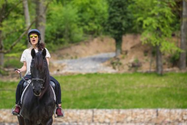 Güneş gözlüklü, güzel genç esmer bir binicilik