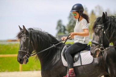 Güneş gözlüklü, güzel genç esmer bir binicilik