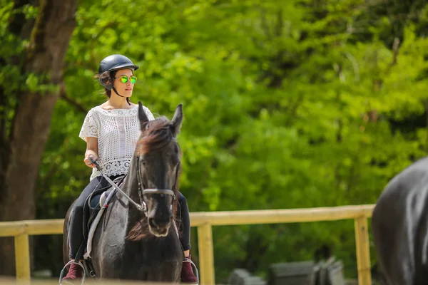 馬に乗ってサングラスの素敵な若いブルネット — ストック写真