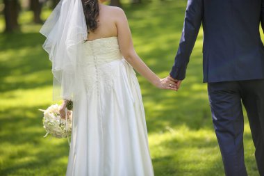 Gelin ve damat el ele tutuşuyorlar. 