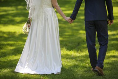 Gelin ve damat el ele tutuşuyorlar. 