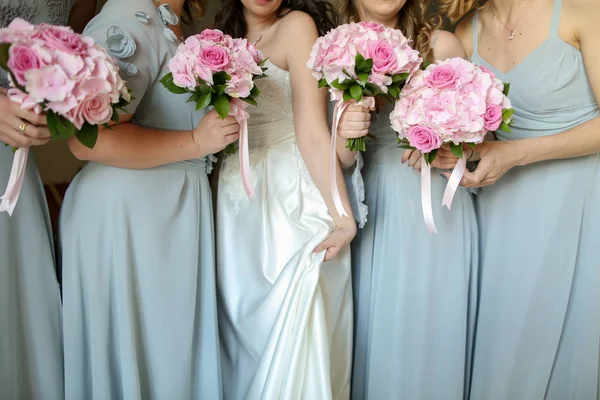 Bruid met bloemen en meiden — Stockfoto