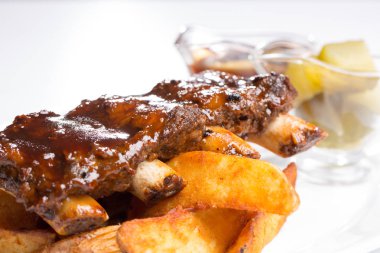 Lezzetli domuz kaburga sos ve bir plaka üzerinde salatalık ile