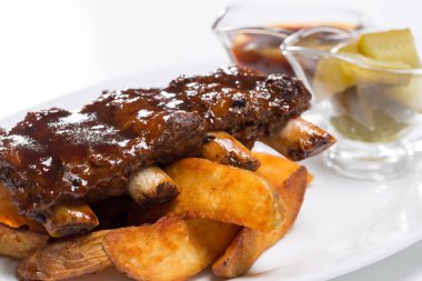 Lezzetli domuz kaburga sos ve bir plaka üzerinde salatalık ile