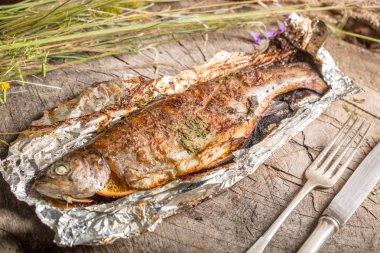 Bir alüminyum folyo üzerinde ızgara bütün alabalık 