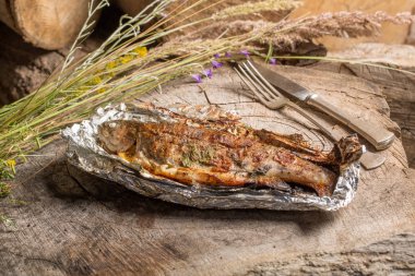 Bir alüminyum folyo üzerinde ızgara bütün alabalık 