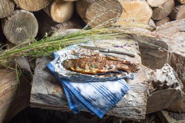 Bir alüminyum folyo üzerinde ızgara bütün alabalık 