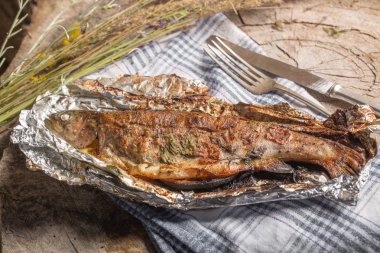 Bir alüminyum folyo üzerinde ızgara bütün alabalık 