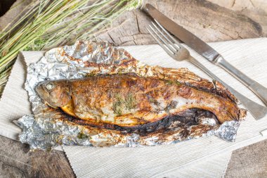 Bir alüminyum folyo üzerinde ızgara bütün alabalık 