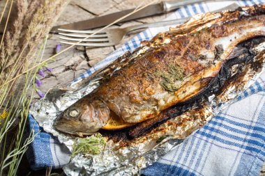 Bir alüminyum folyo üzerinde ızgara bütün alabalık 