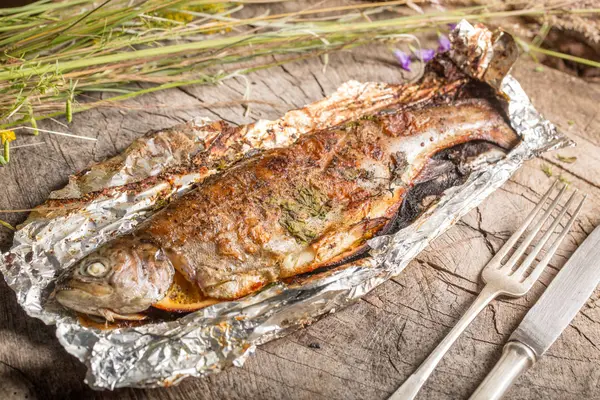 Bir alüminyum folyo üzerinde ızgara bütün alabalık 