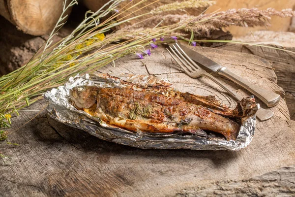 Bir alüminyum folyo üzerinde ızgara bütün alabalık 