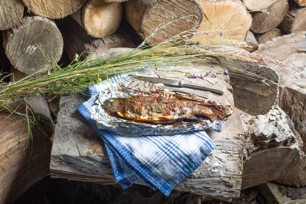 Bir alüminyum folyo üzerinde ızgara bütün alabalık 