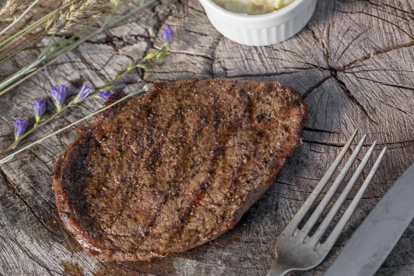 Bir rustik ahşap seyir defteri, sarımsak sosu ve eski sığır eti biftek