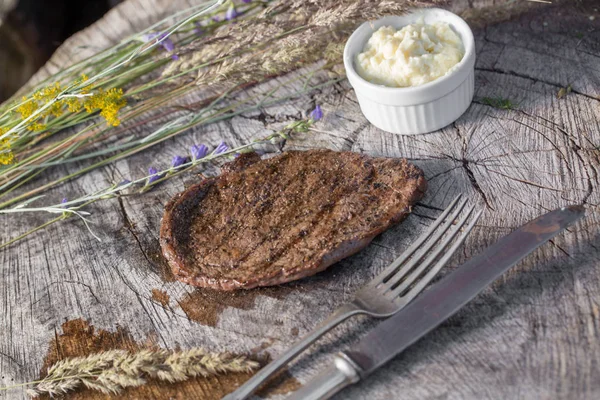 Bir rustik ahşap seyir defteri, sarımsak sosu ve eski sığır eti biftek
