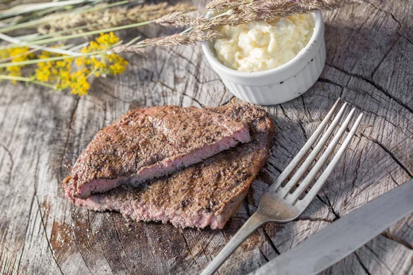 Bir rustik ahşap seyir defteri, sarımsak sosu ve eski sığır eti biftek