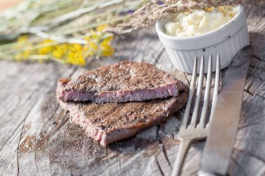 Bir rustik ahşap seyir defteri, sarımsak sosu ve eski sığır eti biftek