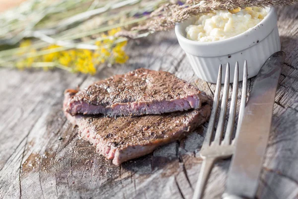 Bir rustik ahşap seyir defteri, sarımsak sosu ve eski sığır eti biftek